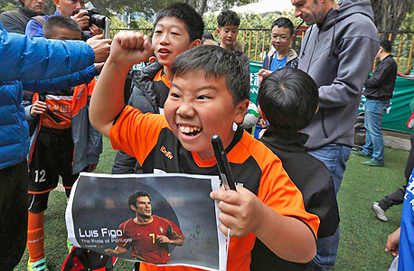 אוהד כדורגל סיני צעיר. "הכדורגל הוא ספורט פופולארי אבל לא משחקים אותו", צילום: רויטרס