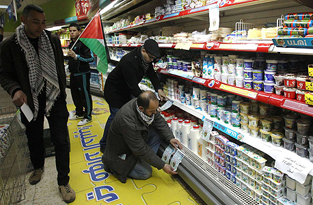 פעילים תולים עלונים הקוראים לחרם מוצרים מישראל במכולת בבית לחם