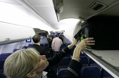 דיילת סוגרת את תאי האחסון במטוס. המטרה היא לאפשר ל-120 נוסעים להעלות  תיק לטיסה