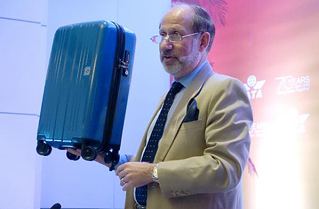 סגן נשיא איגוד התחבורה האווירית הבינלאומית מדגים את גודל התיק המומלץ, צילום: איי אף פי