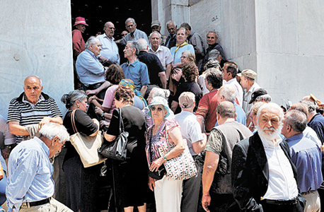 פנסיונרים מתגודדים מול סניף בנק סגור כדי לקבל קצבה, אתמול בסלוניקי