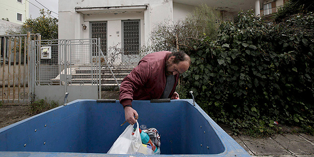 מובטל יווני באתונה מחטט בפח זבל, צילום: אי פי איי