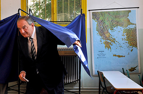 ראש ממשלת יוון לשעבר קוסטס קרמנליס מצביע במשאל עם