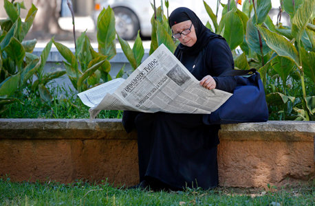 נזירה יווניה מתעדכנת על המהלכים , צילום: רויטרס