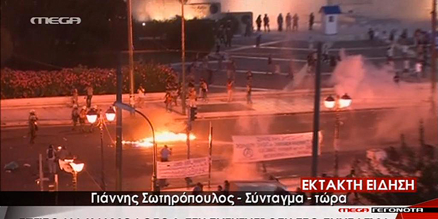 בקבוקי תבערה וגז מדמיע מחוץ לפרלמנט באתונה: &quot;הדגל הנאצי לא יונף מעל האקרופוליס&quot; 
