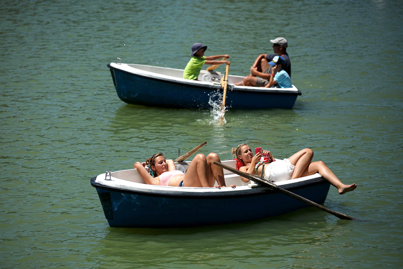 תושבי מדריד משתזפים על בוציות, באגם שבפארק אל רטירו, צילום: גטי אימג