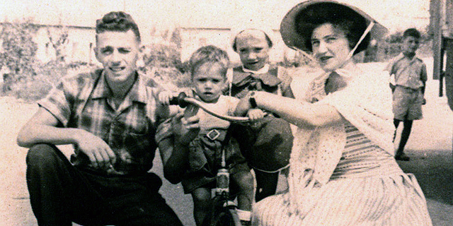 1959. איציק אברכהן, בן 4, עומד במרכז, עם אחיו רענן בן השנתיים והוריו אברהם ורותי, ליד הבית במגדל העמק