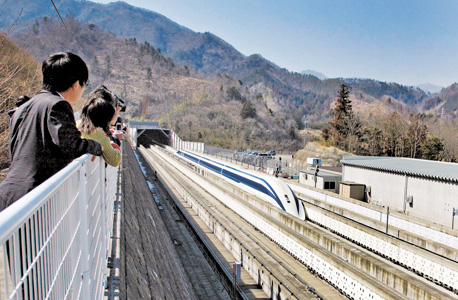 עיתונאים ביפן צופים בנסיעת מבחן של רכבת מגְלֶב מרחפת שמגיעה למהירות 500 קמ"ש. ביפן כבר פועלת רכבת מרחפת שנוסעת במהירות 100 קמ"ש