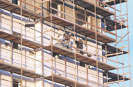 פועלי בניין פלסטינים באתר בנייה בישראל. זוכים לשכר כפול מבתחומי הרשות