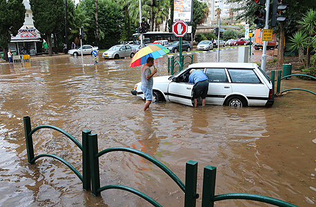 אזרחים מנסים לפתוח פתח ניקוז סתום ברעננה אזרחים מנסים לפתוח פתח ניקוז סתום ברעננה
