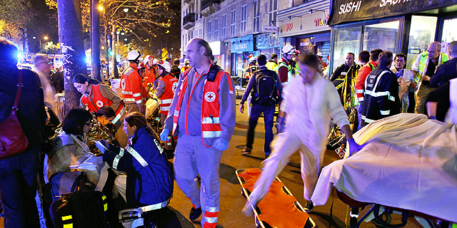 פינוי פצועים בפריז ליד התיאטרון שבו אירע הטבח, צילום: איי פי