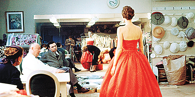 כריסטיאן דיור (משמאל, בחלוק לבן) בוחן שמלת ערב בעיצובו לפני תצוגה (ינואר, 1957), צילום: גטי אימג