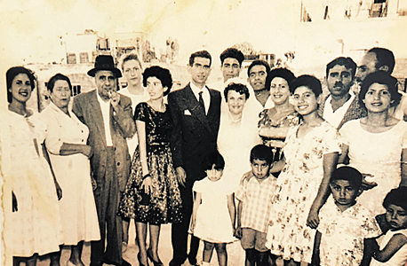 1960. רמי לוי, בן חמש (שני מימין בחולצה פרחונית), עם אמו (בשמלה לבנה מאחוריו) ואביו (מאחוריה), בחתונה משפחתית בירושלים