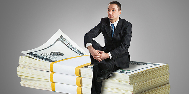 An investor sitting on a pile of cash. Photo: shutterstock