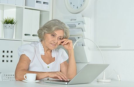 אישה מבוגרת עובדת על מחשב גיל פרישה פנסיה, צילום: שאטרסטוק