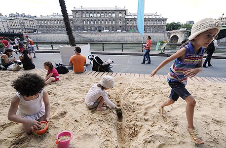 ילדים משחקים בחול על גדות הסיין בפריז. מעכשיו גם באיצטדיון, צילום: איי אף פי