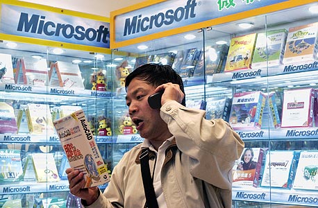 לקוח מדבר בטלפון בחנות מיקרוסופט בסין. טרויאני ששולח הודעות סמס, צילום: בלומברג