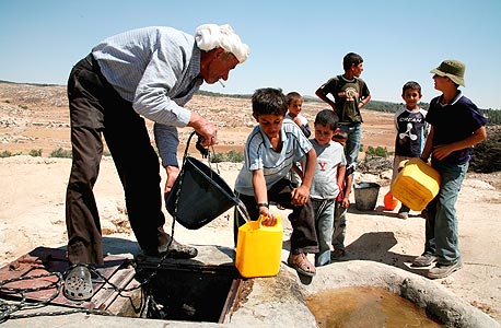 פלסטינים ממלאים מים בכפר יטא, צילום: אי פי אי