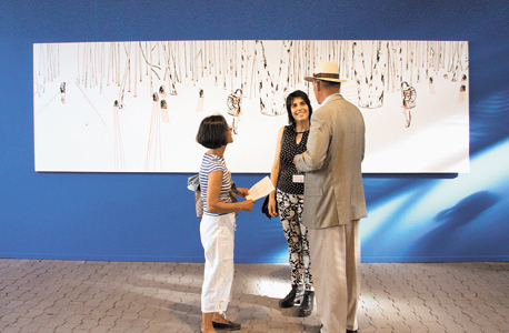 האמנית מרב שין בן־אלון עם שניים מהמבקרים בתערוכה. ברקע ציור שלה ובו היער שמשפחתה ברחה אליו בזמן השואה האמנית מרב שין בן־אלון עם שניים מהמבקרים בתערוכה. ברקע ציור שלה ובו היער שמשפחתה ברחה אליו בזמן השואה