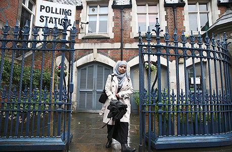 משאל העם בריטניה האיחוד האירופי אישה מוסלמית יוצאת מהקלפי בצפון לונדון, צילום: רויטרס