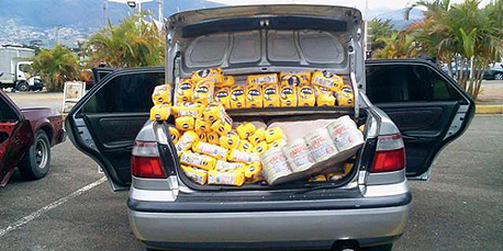 כך נראה השוק השחור בונצואלה. חבילות קמח שהוברחו למדינה נמכרות מתא המטען של הרכב 