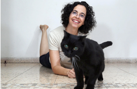 אוצרת התערוכה מיכל פז קלפ עם החתול האישי, צילום: שאול גולן