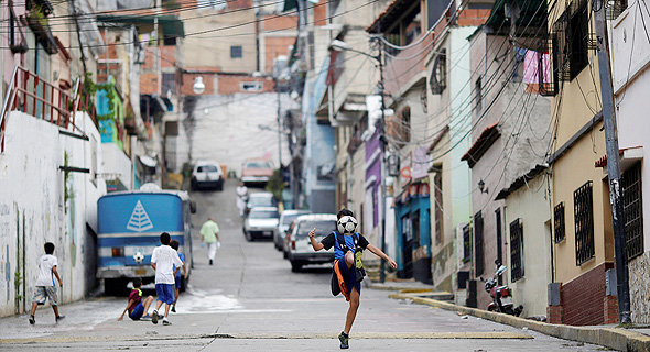 ילד משחק כדורגל בוונצואלה.  מספר השחקנים שהיגרו מהמדינה שלהם בעודם עדיין קטינים, עלה מ-444 בשנת 2009 ל-597 השנה. כיום, 13.8% מהשחקנים בחמש הליגות הבכירות עזבו את המדינה שלהם לפני גיל 18. נתון זה עומד על 10.1% עבור 31 הליגות באירופה., צילום: רויטרס