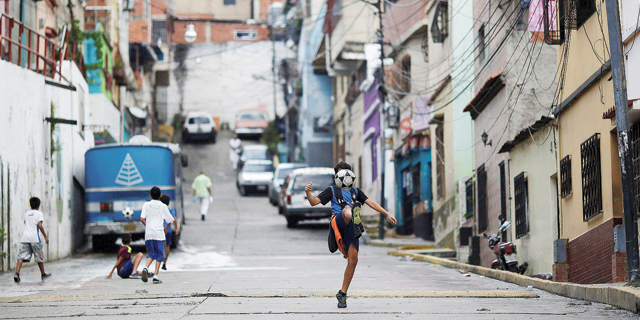 ילד משחק כדורגל בקראקס, ונצואלה. זה מספר הקטינים (מתחת לגיל 18) שעזבו את מדינותיהם והצטרפו לקבוצה באחת מחמשת הליגותהגדולות ב־2016. פי 3.8 יותר מאשר ב־1995, צילום: רויטרס