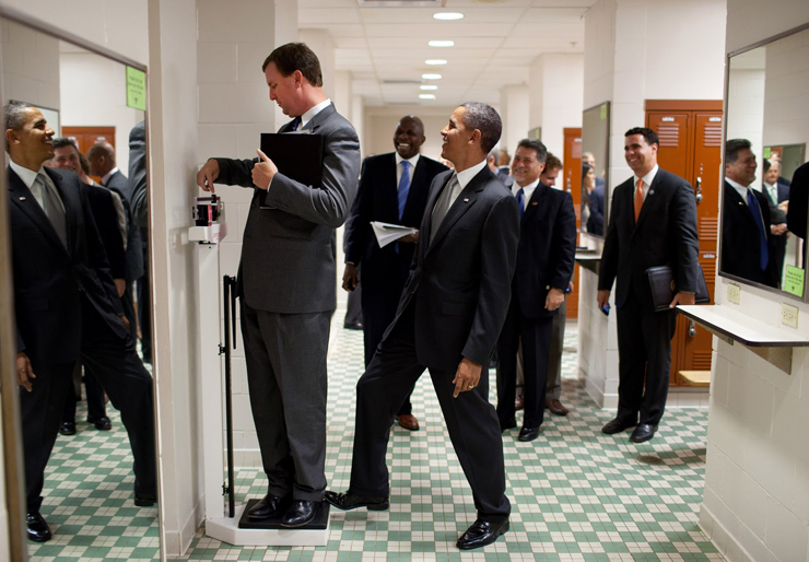 אוגוסט 2010. הנשיא משתעשע עם מנהל הסיורים שלו, מרווין ניקולסון, שמנסה לשקול את עצמו  בשעה שפמליית הנשיא עוברת בחדר ההלבשה של אולם הספורט באוניברסיטת טקסס באוסטין, צילום: Pete Souza / The White House