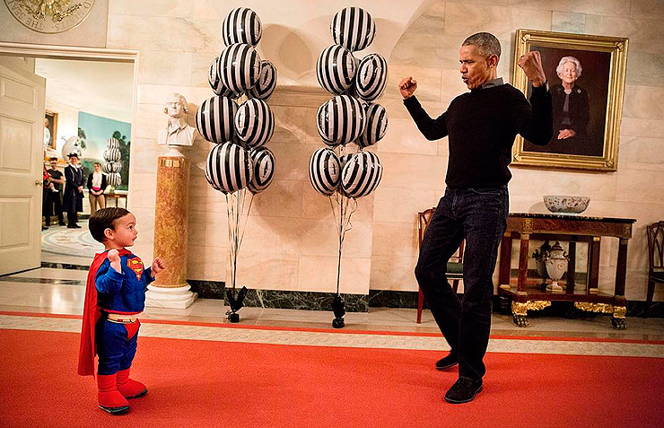 אוקטובר 2016. חג הלואין, הנשיא אובמה מראה לבנו של דובר הבית הלבן המחופש לסופרמן כיצד לנפח את שריריו