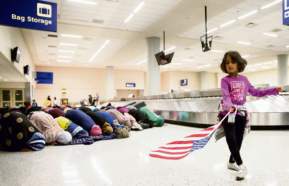 תפילת מחאה של מוסלמיות נגד איסור הכניסה לארצות הברית, בנמל התעופה בדאלאס ביום ראשון. בנון הוביל את ההחלטה על הצו, שספגה ביקורת אפילו ממקורבי טראמפ, צילום: רויטרס