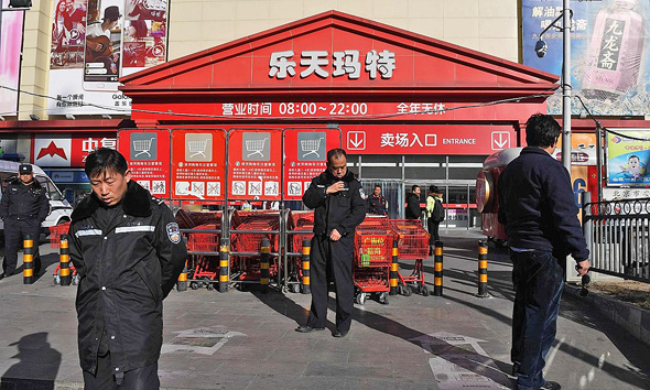 השבוע: שוטרים שומרים על סופרמרקט לוטה בבייג'ינג  מפני פגיעת מפגינים