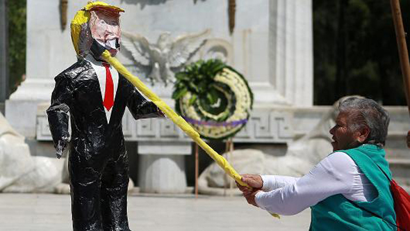 אזרח מקסיקו מכה בובה בדמותו של טראמפ