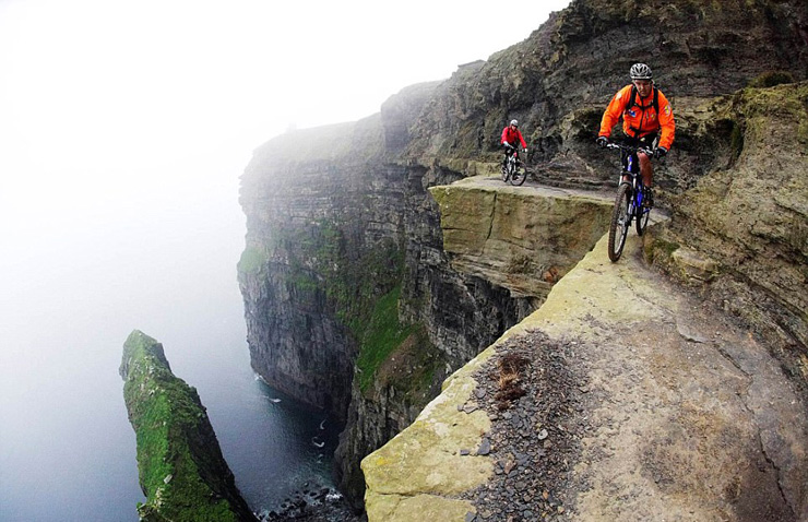 רוכבים על אופניים בשולי צוקי מוהר (Cliffs of Moher) באירלנד 