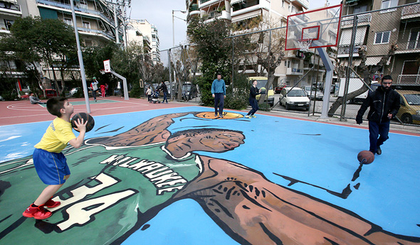 מגרש כדורסל מכוסה בציור של אנטטוקומפו בשכונת ילדותו ספוליה באתונה. "ליוון יש חלק אדיר במה שאני"