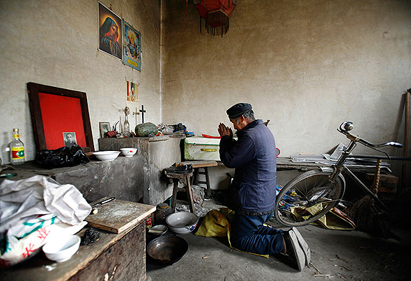 נוצרי סיני מתפלל בביתו