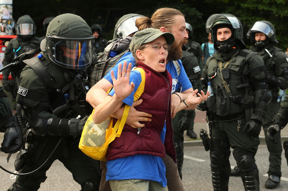 שוטרים עוצרים מפגינה מחוץ לפסגת G20 בהמבורג, צילום: איי פי