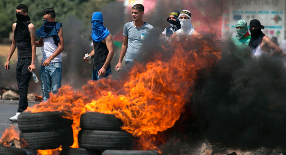 מפגינים שורפים צמיגים במחסום חווארה, היום, צילום: איי אף פי