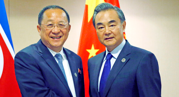 מימין: שר החוץ של סין Wang Yi ועמיתו מצפון קוריאה Ri Yong Ho בפגישה היום במנילה
