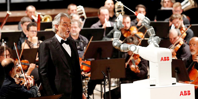הרובוט יומי מנצח על התזמורת לצד זמר הטנור אנדריאה בוצ