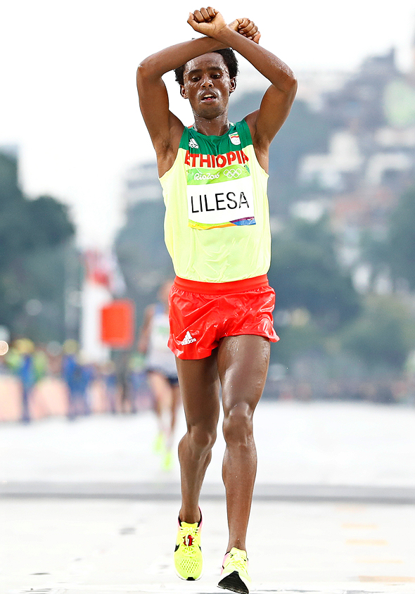  הרץ האתיופי, זוכה מדליית הכסף במרתון באולימפיאדת ריו, פייסה לילסה, מצליב את ידיו לאות הזדהות עם בני האורומו