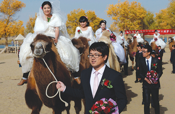 זוגות טריים בחתונת המונים במחוז שינג'יאנג, סין. מקובל שמשפחת החתן משלמת "מחיר כלה" עבור הזכות להינשא