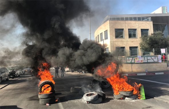 עובדים שורפים צמיגים במפעלי טבע בירושלים, אתמול, צילום: Twitter/amit1tomer