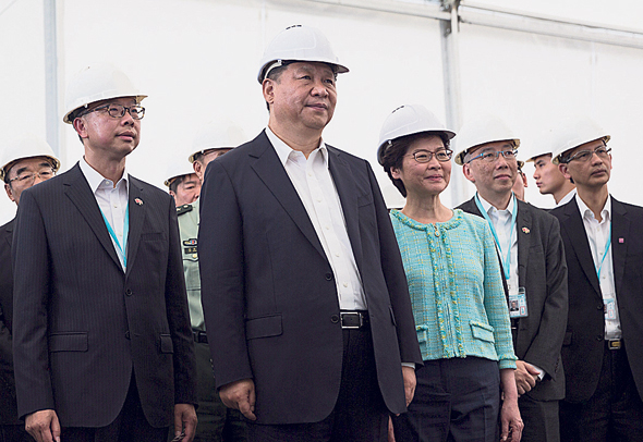 נשיא סין שי ג'יאנפינג (במרכז) באתר הבנייה ביולי. עוד דרך להגביר את המעורבות הסינית בהונג קונג