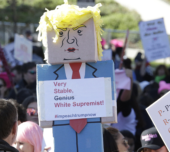 מפגינה מניפה שלט בדמותו של טראמפ בדאבוס שוויץ, צילום: אי פי איי