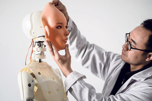 מדען סיני בוחן רובוט דמוי אדם