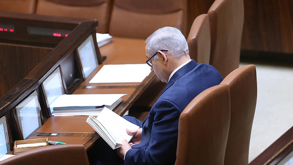 נתניהו קורא ספר במליאה, בזמן הדיונים, צילום: אלכס קולומויסקי