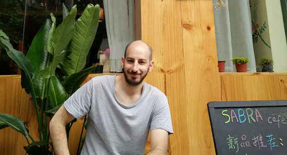 עומר קפשוק בכניסה לבית הקפה שלו בלשאן, צילום: אופיר דור