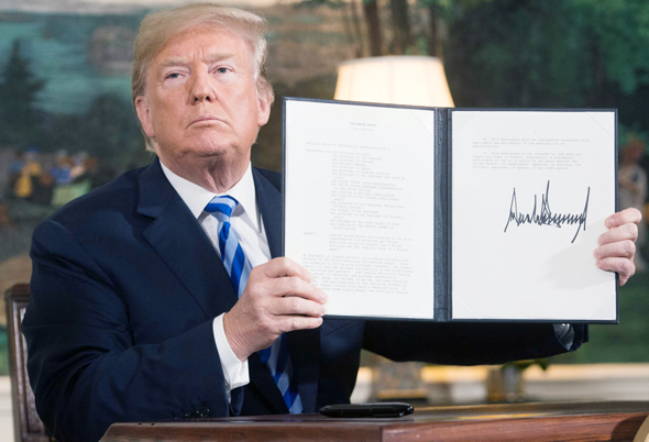 נשיא ארה"ב דונלד טראמפ חותם על צו נשיאותי ליציאה מהסכם הגרעין שלשום, צילום: איי אף פי