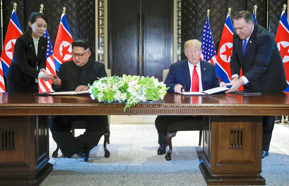דונלד טראמפ וקים ג'ונג און בחתימה על ההסכם